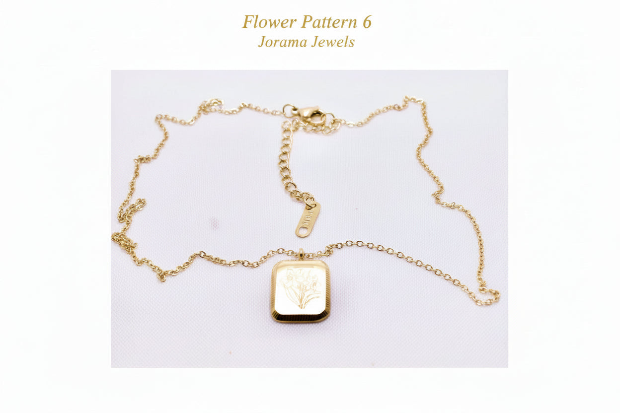 Gold necklace with a rectangular pendant on a light white background