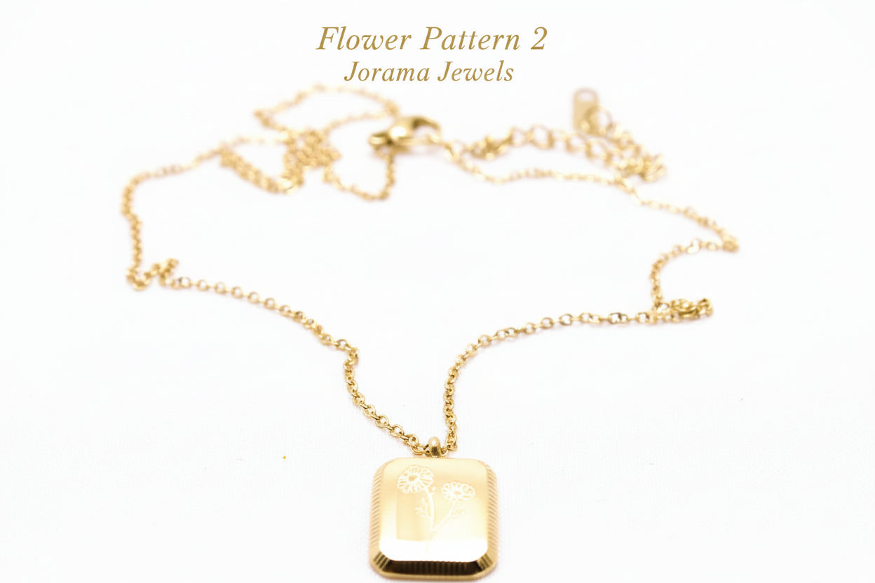 Gold necklace with a rectangular pendant on a light white background