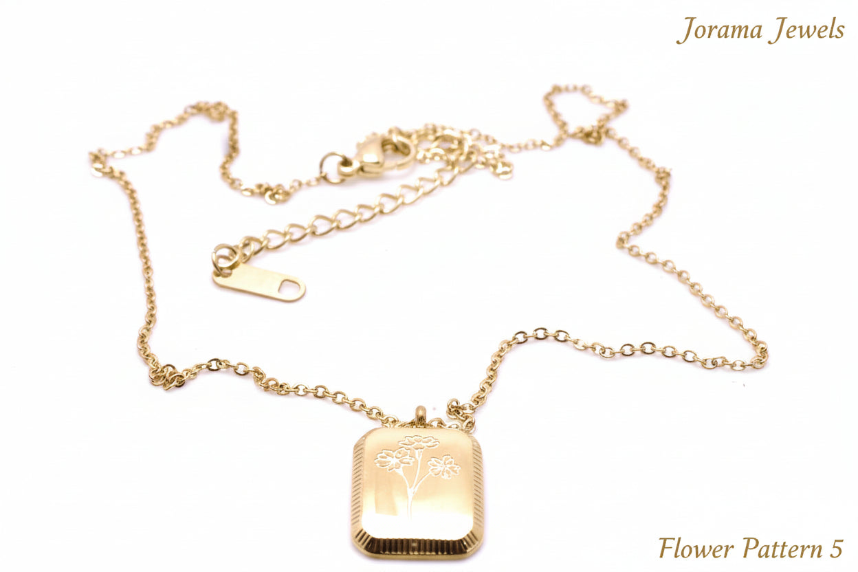 Gold necklace with a rectangular pendant on a light white background