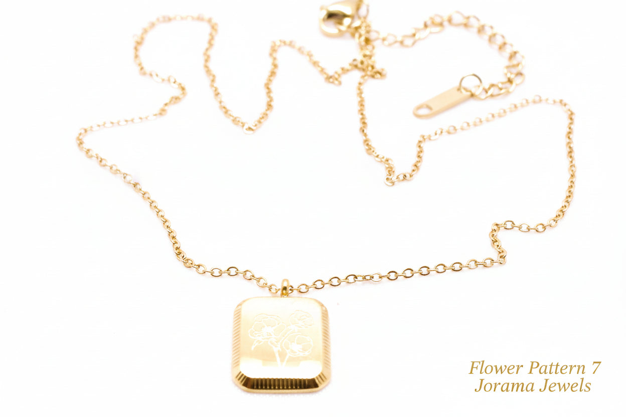 Gold necklace with a rectangular pendant on a white background