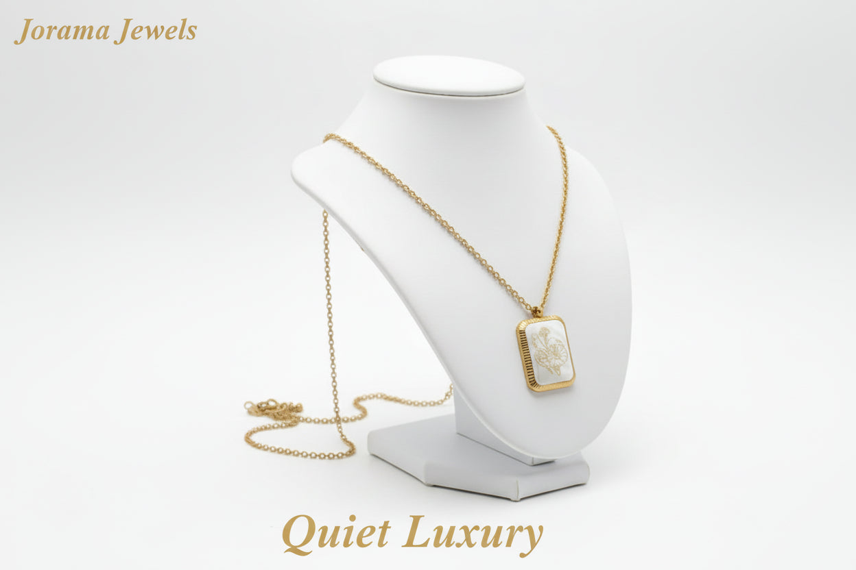 A gold-colored square flower pendant necklace displayed against a white background.