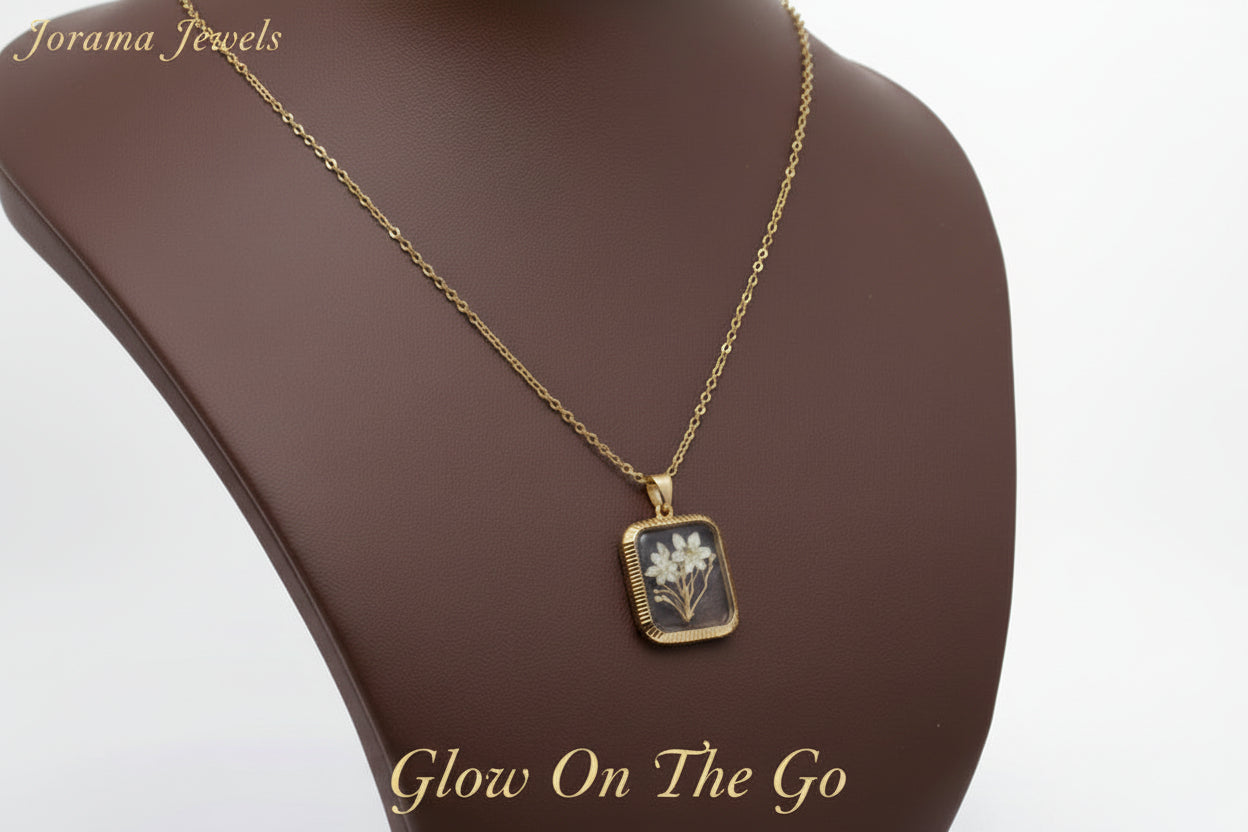 A gold-colored square flower pendant necklace displayed against a white background.