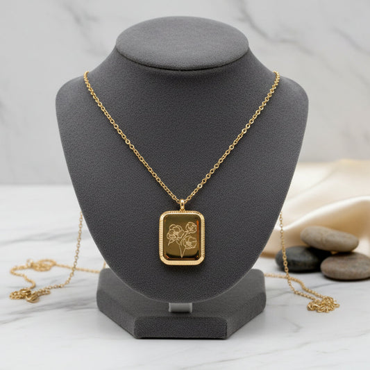 A gold-colored square flower pendant necklace displayed against a white background.