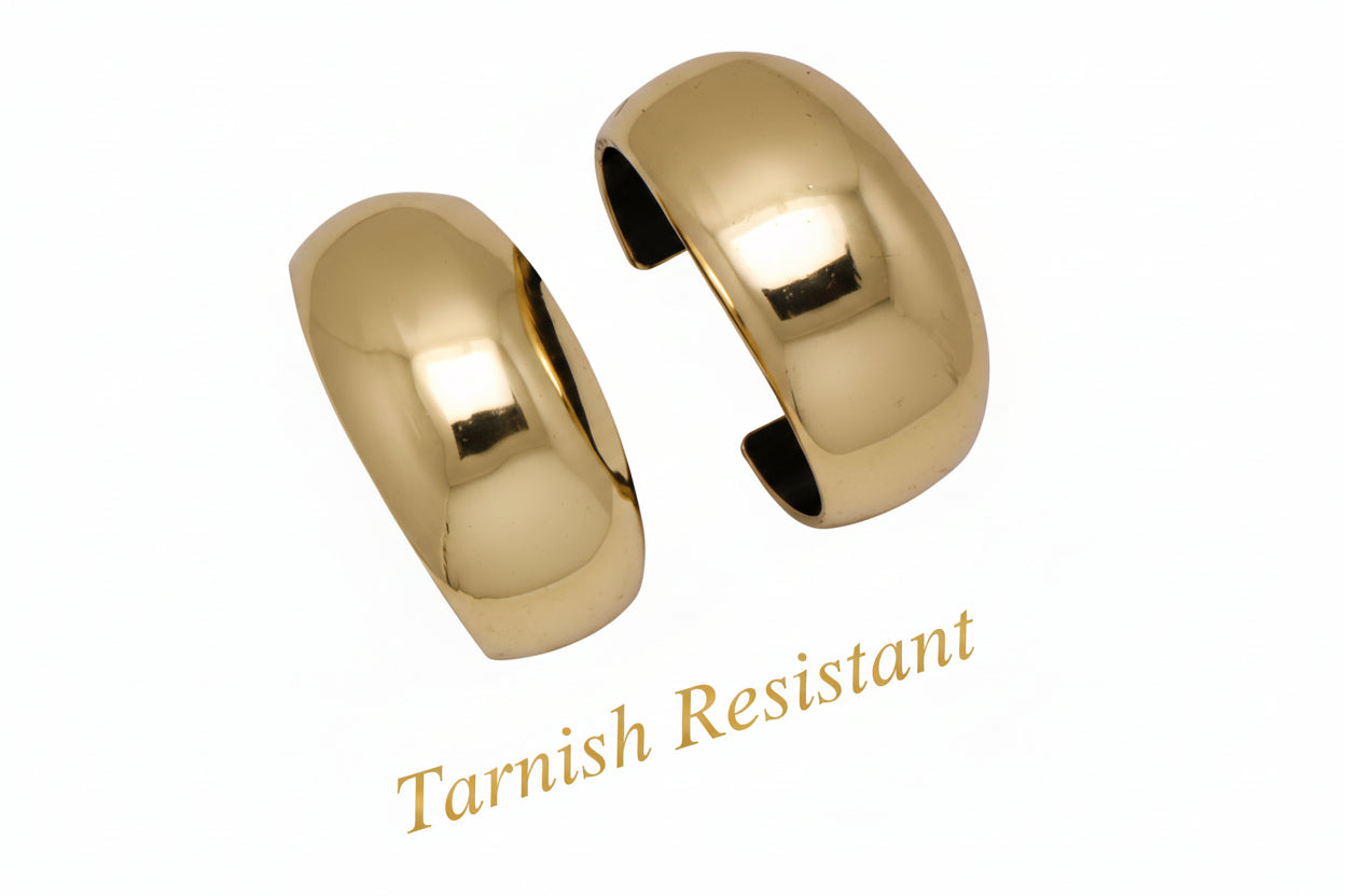 Two gold metal cuffs on with white dotted background.