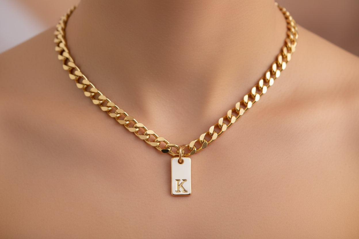 Gold chain necklace with a 'K' pendant on a mannequin