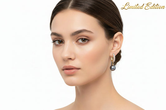 Pair of earrings with black pearls on a white background