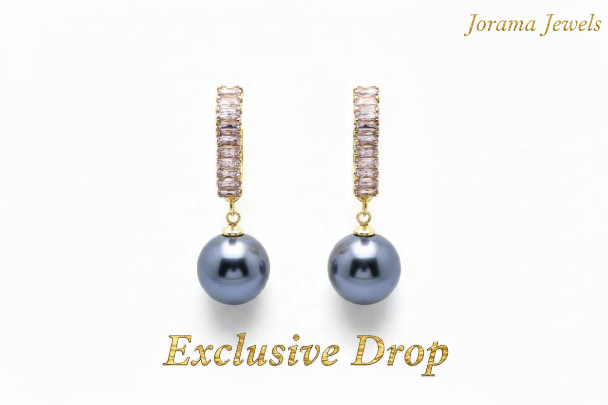 Pair of pearl earrings with gold accents on a light gray background