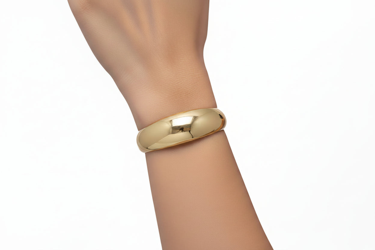 Gold crescent moon-shaped cuff on a light gray background